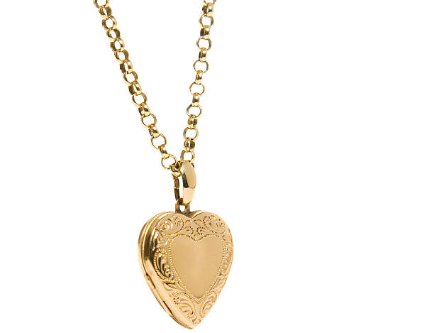 Heart Shaped Locket "An old fashioned gold heart shaped locket hanging on a gold chain, shot against a white backdrop.Similar images from my portfolio:" locket stock pictures, royalty-free photos & images