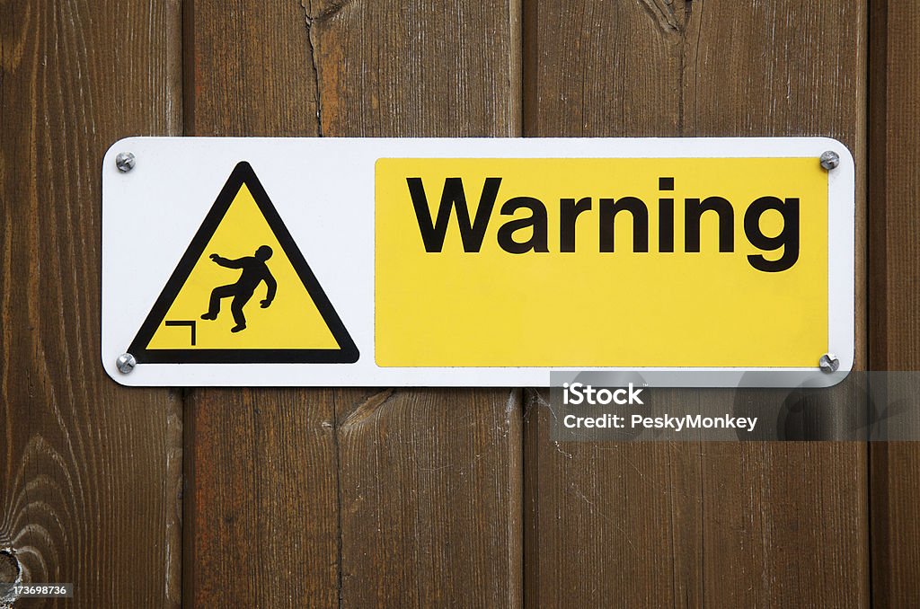 Warning Sign in Yellow with Falling Man Bright yellow warning sign shows a man falling Construction Industry Stock Photo