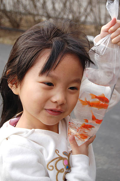 Gen Z Girls exploring Gold Fish Street happily in Mongkok, Kowloon, Hong Kong. They feel excited to different types of fish.