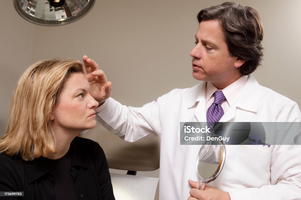 Medical Doctor Consults with Patient A plastic surgeon consults with a patient. Adult Stock Photo