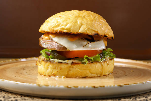 istock Burger with beef tongue, cheese salad and tomato close-up. Selective focus 1737002796