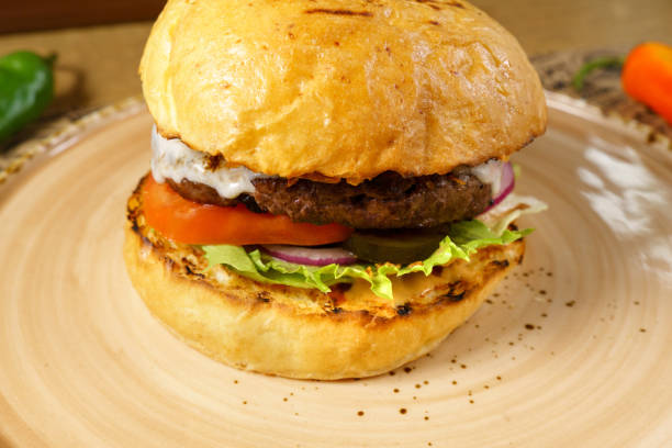 istock Burger with beef patty, cheese salad and tomato close-up. Selective focus 1737003269