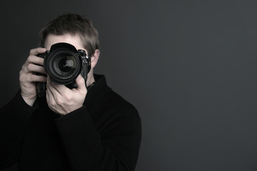Portrait of a photographer with camera in front of his face