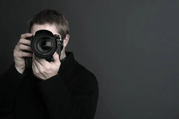 Photo of Portrait of a photographer with camera in front of his face