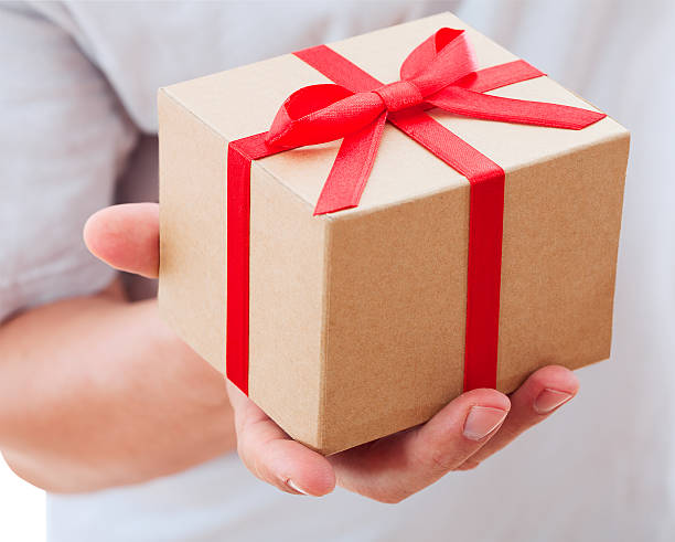 istock male hand holding gift with ribbon. 173702048