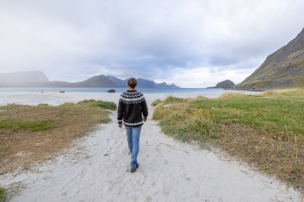 Male wandering on the coastline of Norway, Autumn season. Peace and tranquility.