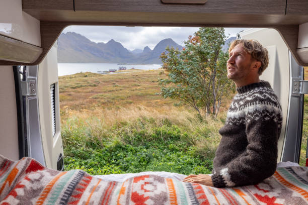 istock Road trip- Man outside his camper van enjoying nature 1737046309