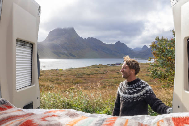 istock Road trip- Man outside his camper van enjoying nature 1737046368