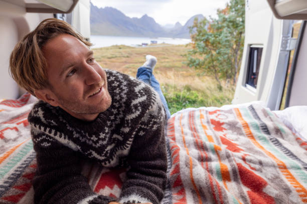 istock Road trip- Man in his camper van relaxing on the bed 1737046370