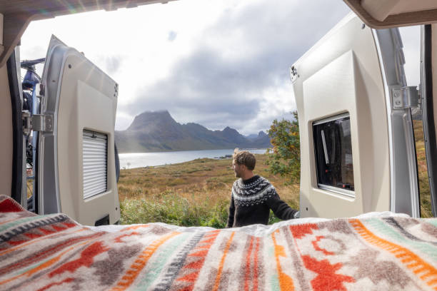istock Road trip- Man outside his camper van enjoying nature 1737047034