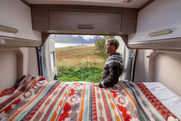 istock Road trip- Man outside his camper van enjoying nature 1737047996