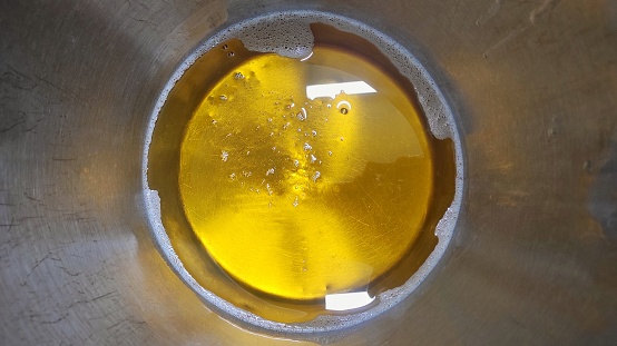 Oil which is like honey in the metal bucket for cooking