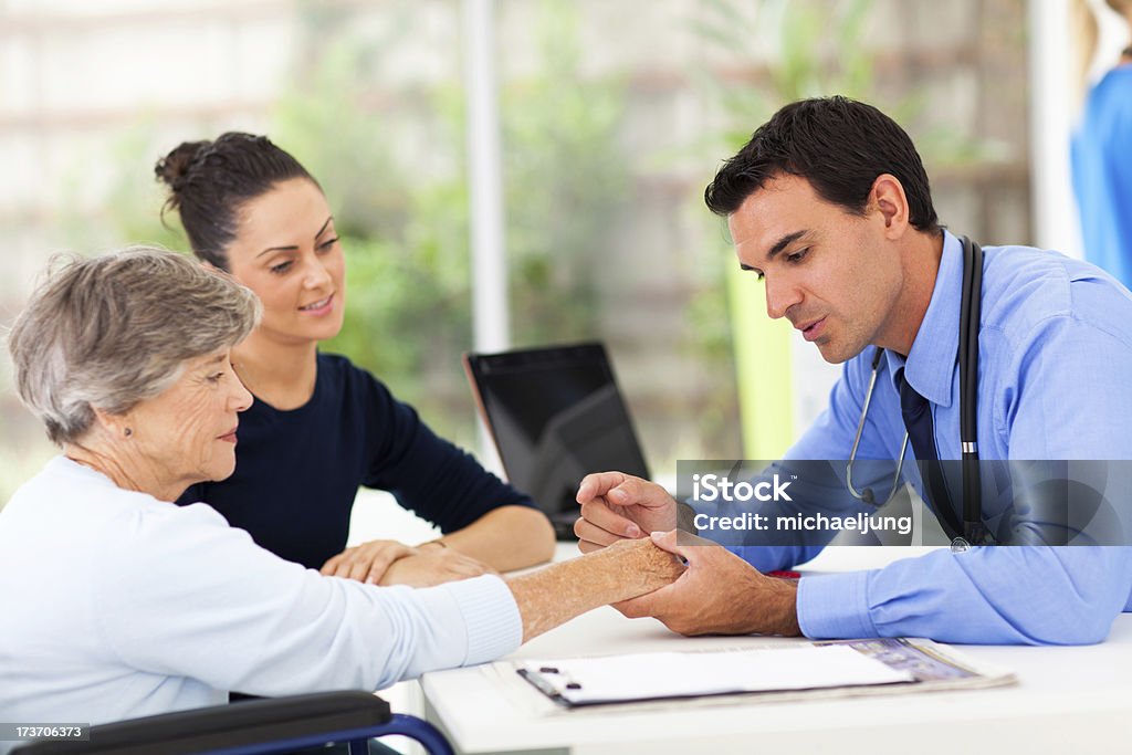 dermatologist Inspecionar paciente sênior da pele - Foto de stock de Dermatologia royalty-free