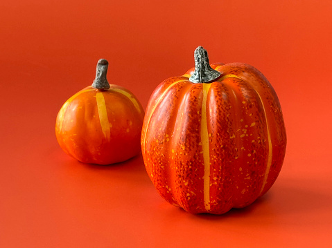 Stock photo showing close-up view of autumnal fake, orange plastic pumpkin Halloween decorations.