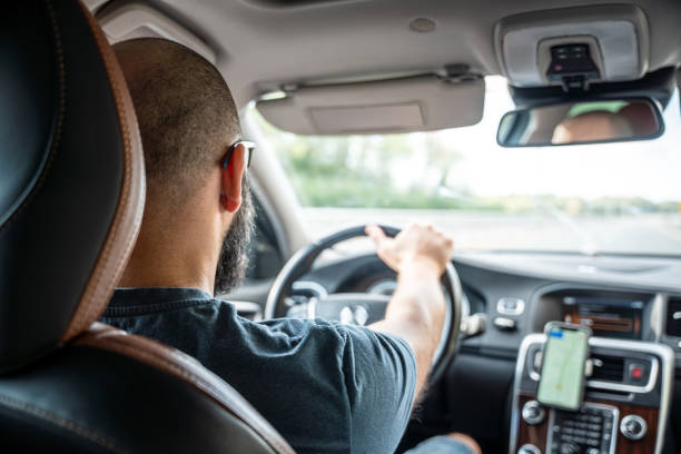 istock Man driving a car at the multiple lane highway, rear view 1737071532