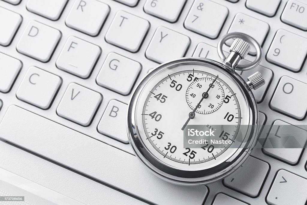 Stopwatch on a keyboard Close up of analog stopwatch on a laptop keyboard with copy space Stopwatch Stock Photo
