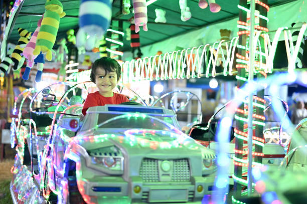 Asian toddler driving a toy car