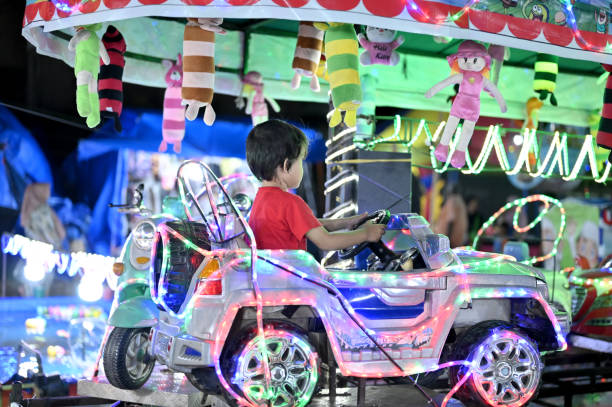 Asian toddler driving a toy car