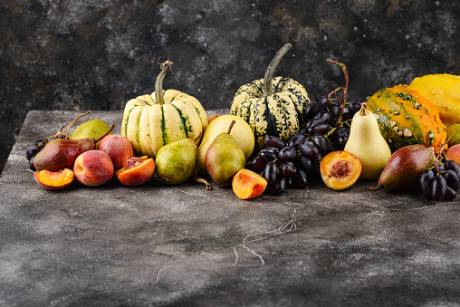 Assortment of autumn fruit. Pear, peach, grapes and pumpkin
