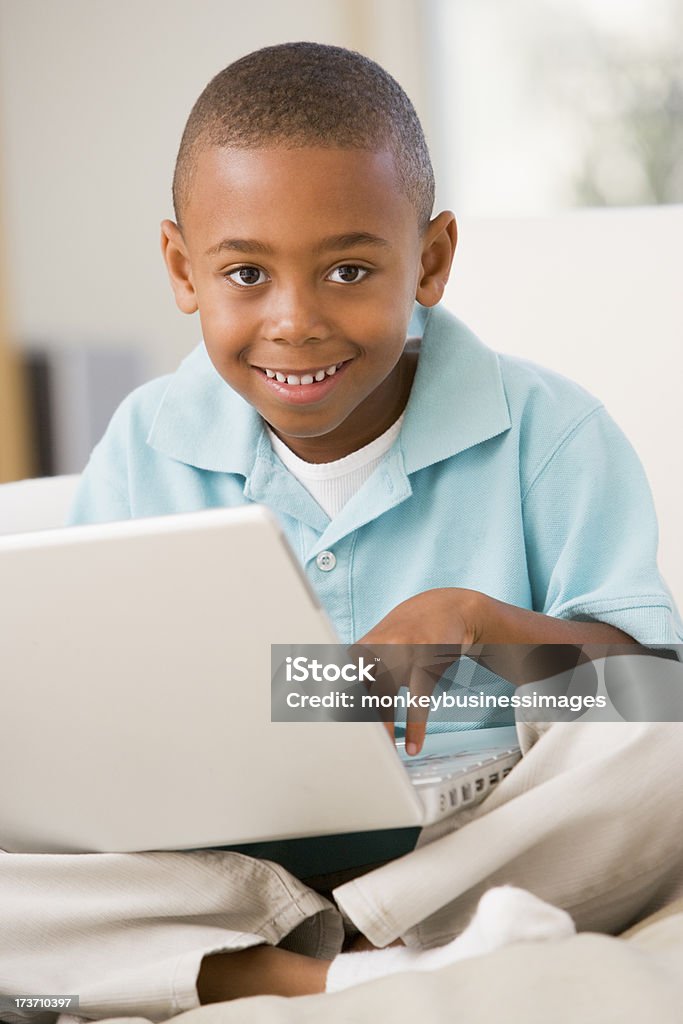 Junge im Wohnzimmer mit laptop lächelnd - Lizenzfrei Afrikanischer Abstammung Stock-Foto