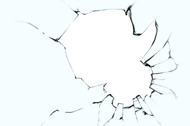 istock Broken glass with cracks and a big hole. Black cracks on blue glass with a white background. 1737108472
