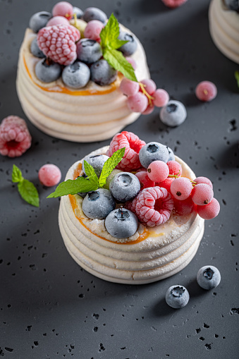 Sweet mini Pavlova dessert with frozen berries and meringue. Pavlova dessert with frozen blueberries and raspberries.