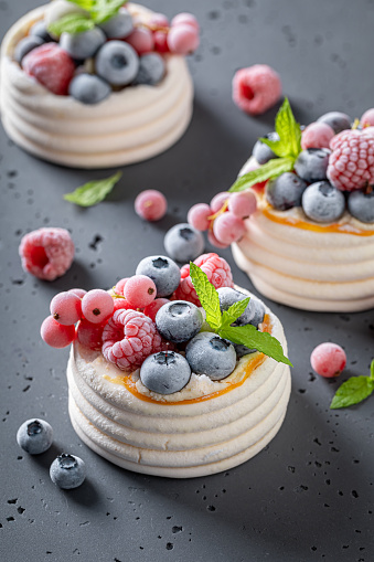 Creamy mini Pavlova dessert made of mascarpone and frozen berries. Dessert made of meringue with cream and frozen berries.