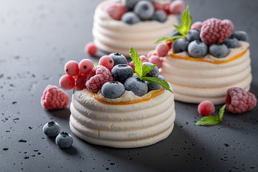 Homemade mini Pavlova dessert with frozen berries and meringue. Dessert made of meringue with cream and frozen berries.