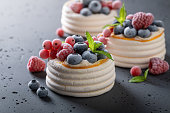 Homemade mini Pavlova dessert with frozen berries and meringue.