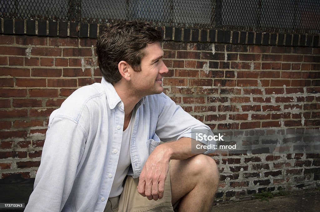 Gut aussehender Mann kniend durch Old Warehouse - Lizenzfrei Alt Stock-Foto