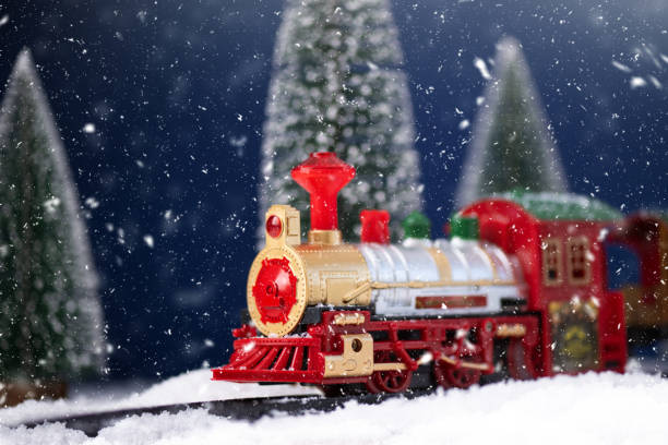 istock Toy train on railway in the snow with Christmas tree. 1737142544