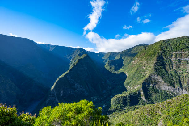 istock Atmospheric afternoon sunshine falls into green overgrown mountain formations with beautiful valleys and natural riverbeds, photographed from the hiking trail. Grand Bassin waterfall, Reunion Island, France, Europe. 1737151839