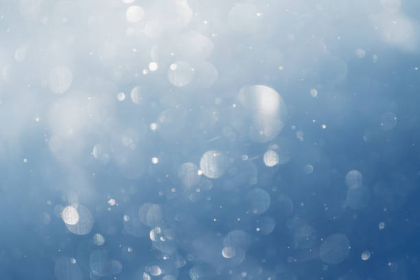 istock Glowing bokeh abstract background.. Snowflakes spin and glow in the air. 1737158664
