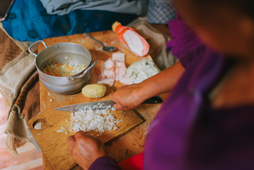 Mongolian woman cutting potato preparing traditional food dumpling buuz