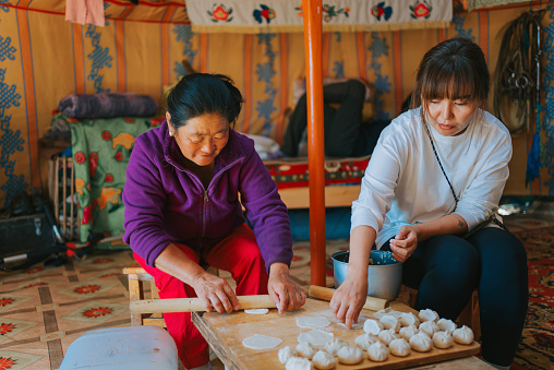 Mongolian nomadic women preparing traditional dumpling, buuz inside Ger, traditional yurt tent