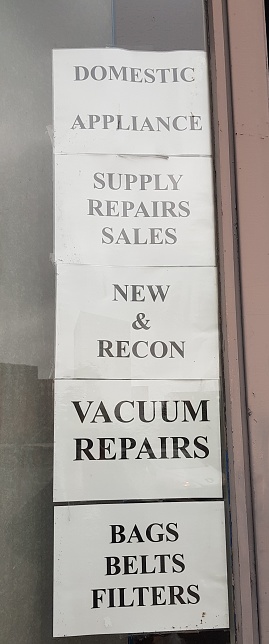 Domestic Appliance, Supply Repairs Sales, New & Recon, Vacuum Repairs, Bags Belts Filters information sign on a shop window on the streets of Glasgow Scotland UK