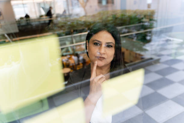 istock Pensive Indian businesswoman using sticks notes having idea, brainstorming in modern office . Scrum 1737228750