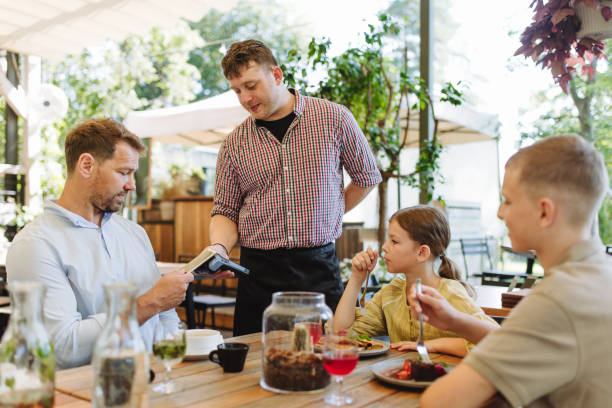 istock Man paying for lunch in a restaurant by card. 1737238441