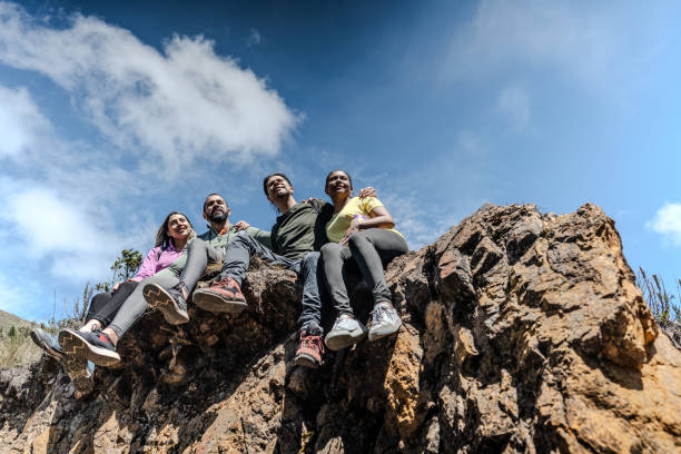 istock Friends looking at view sitting on a mountain peak 1737250449