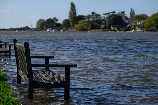 Oulton Broad, Lowestoft, Suffolk. October 14 2023. High tide and heavy rain the night before flooded this urban park with the benches standing in water.
