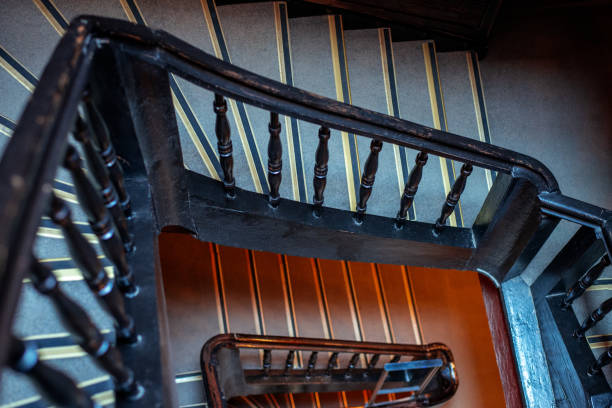 istock High angle view of empty old staircase with black wooden railing. 1737268466