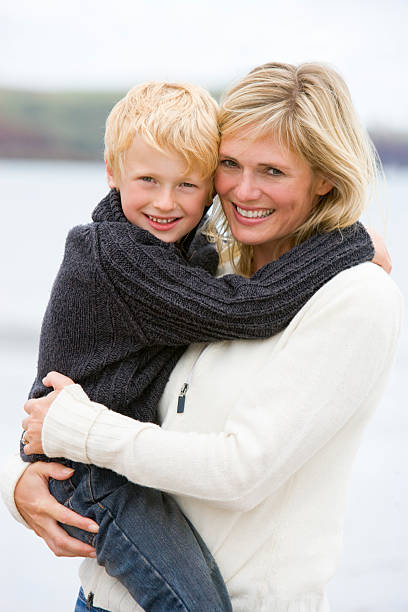 istock Mother holding son at beach smiling 173726958