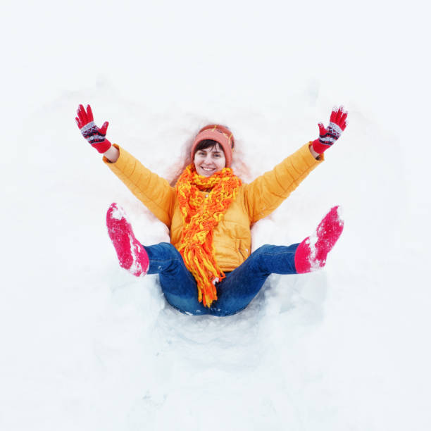 Chinese woman enjoying amazing snowy landscape view - happy and beautiful Asian girl playing with snow in front of frozen lake and mountains during Swiss Alps Winter holiday