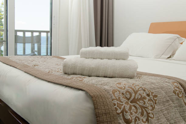 istock Double bed and a stack of white towels on it. 1737283483