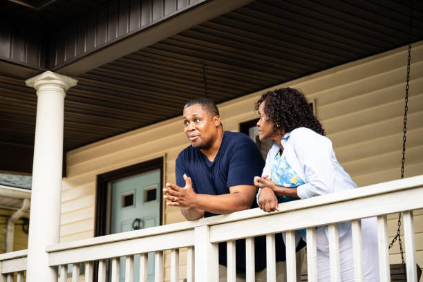обеспокоенная чернокожая пара обсуждает трудные времена - couple porch heterosexual couple 40s стоковые фото и изображения