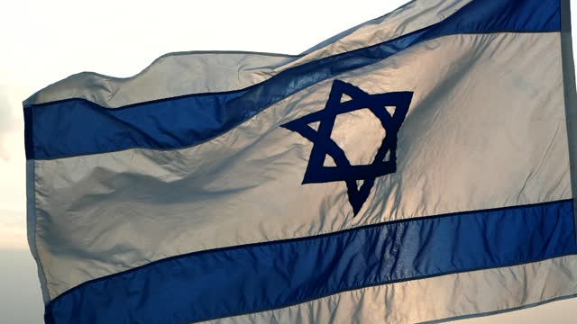 Israel flag with star of David waving against the wind, beautiful sunset outdoor backgrounds. Concept of Israel, Palestine, Iran, Conflict, Gaza, Hamas, War, Freedom, Flag, Independence Day