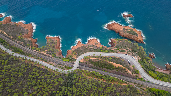 Aerial view of the Massif de L'Esterel and a beautiful winding road over the cliffs falling into the Mediterranean Sea. French Riviera. Cote d'Azur