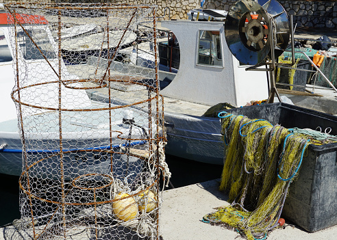 Old traditional fishing boats and fishing equipment on the dock in the small harbor