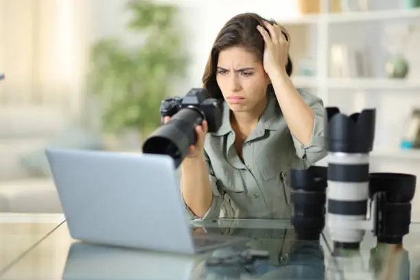 Worried photographer at home checking bad result