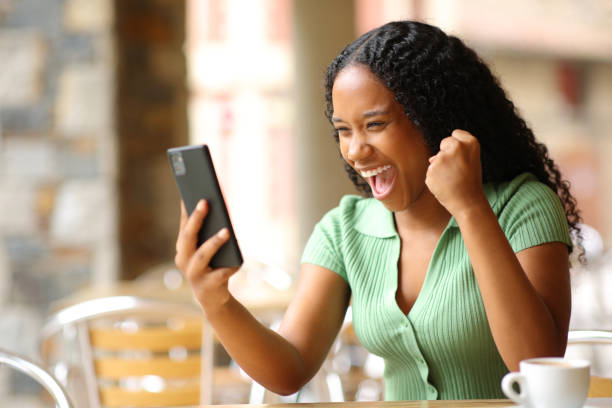istock Excited black woman checking smart phone in a bar 1737326593
